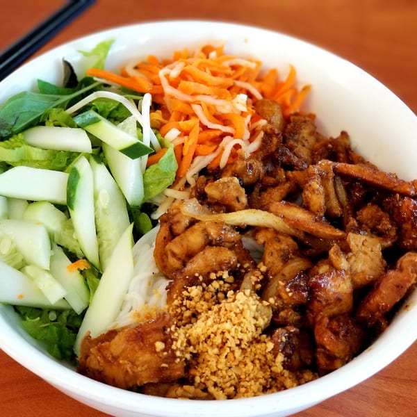 A Vietnamese vermicelli bowl from Lee's Bakery, with grilled pork, fresh vegetables, and crushed peanuts.